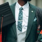 Bilingual Education - A young man in a suit and tie holding a diploma