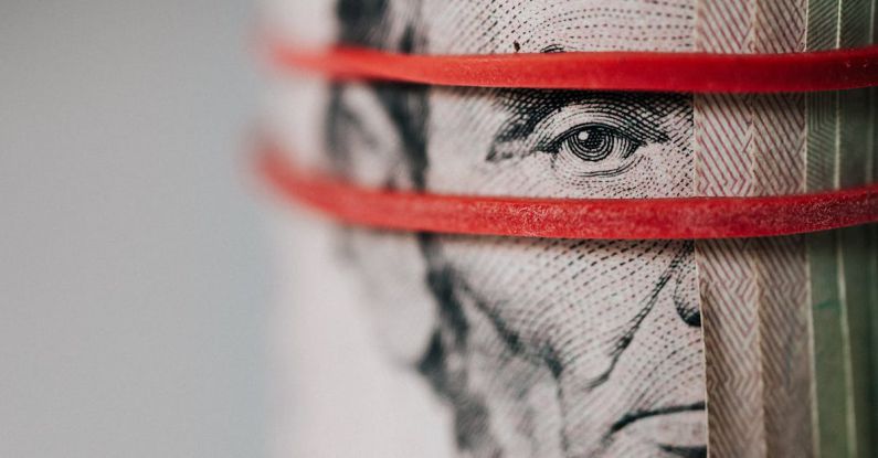 Trade Wars - Closeup of rolled United States five dollar bills tightened with red rubber band