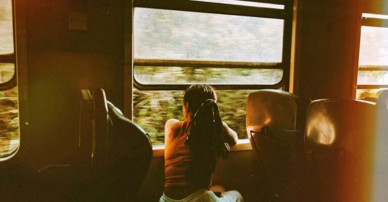 Train Routes - Unrecognizable woman riding train and looking out window