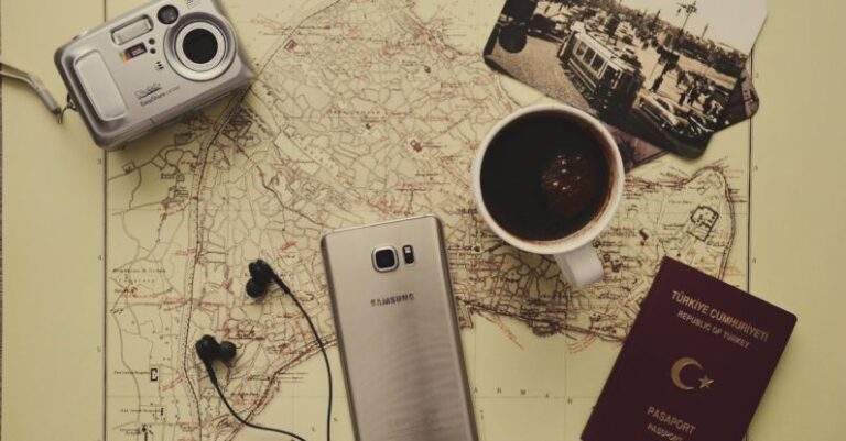 Travel Planning - Silver Camera Near Black Coffee in Mug, Silver Samsung Galaxy S7, Turkey Passport, and Black Earbuds